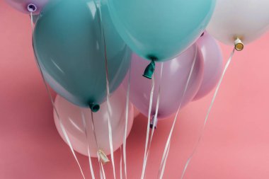 pembe arka plan üzerinde mavi, beyaz ve mor dekoratif şenlikli balonlar