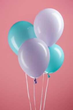 pembe arka planda mavi ve mor renkli şenlikli balonlar