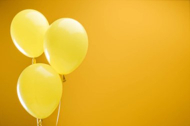 festive bright minimalistic decorative balloons on yellow background with copy space clipart