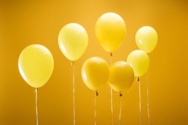 festive bright minimalistic balloons on yellow background clipart