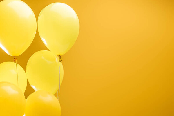 festive minimalistic decorative balloons on yellow background with copy space