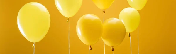 party minimalistic balloons on yellow background, panoramic shot