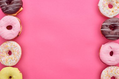 top view of tasty colorful doughnuts on bright pink background clipart