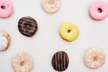 top view of colorful glazed delicious doughnuts on white background clipart