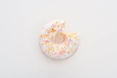 top view of bitten white delicious doughnut with sprinkles on white background clipart