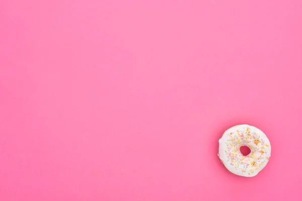 明亮的粉红色背景上美味的釉面甜甜圈的顶视图 — 图库照片