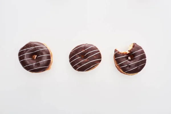 Vista Superior Chocolate Sabrosos Donuts Enteros Cerca Mordido Uno Sobre — Foto de Stock