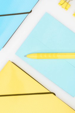 beyaz üzerinde yalıtılmış klasörler, kalem, zarf ve kağıt kliplerle sarı ve mavi kırtasiye