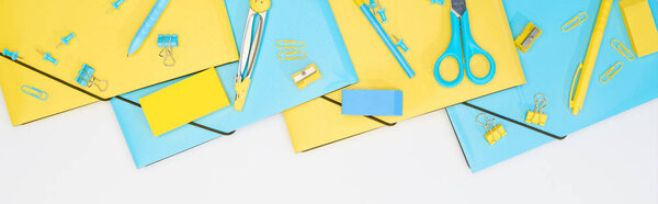 panoramic shot of blue and yellow stationery isolated on white