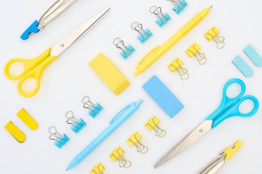beyaz üzerinde izole sarı ve mavi Siliciler, kalemler, makas, pusulalar ve kağıt klipler düz Lay 