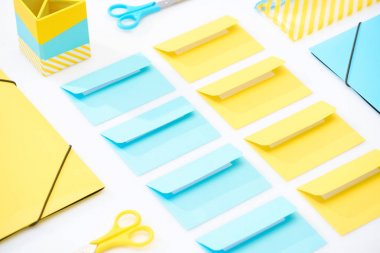flat lay of colourful envelopes, scissors, folders, pencil case and pencil box on white background clipart