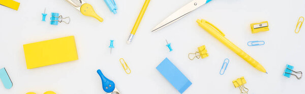 panoramic shot of mixed yellow and blue stationery isolated on white