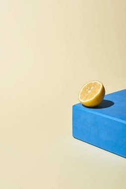 Sarı parlak limon yarısı mavi küp ve bej arkaplan