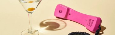 bej arka planda pembe vintage telefon yakın kokteyl ve zeytin ile şeffaf cam panoramik çekim