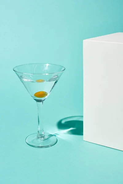 Genomskinligt Glas Med Cocktail Och Oliv Nära Vit Kub Turkos — Stockfoto