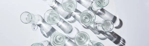 Panoramabild Genomskinliga Glas Med Vatten Vit Bakgrund Med Skuggor — Stockfoto