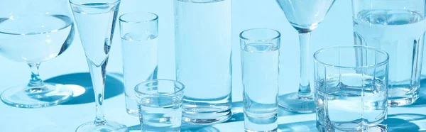 Plano Panorámico Vidrios Transparentes Con Agua Clara Sobre Fondo Azul — Foto de Stock