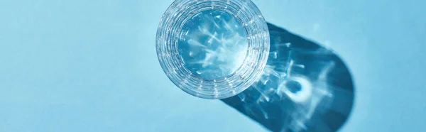 Vista Superior Vidro Com Água Clara Fundo Azul Com Sombra — Fotografia de Stock