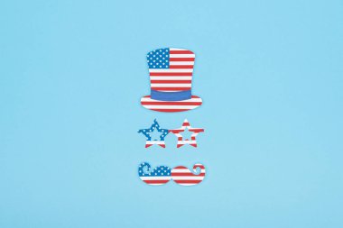 flat lay with paper cut mustache, glasses and hat made of usa flags on blue background clipart