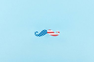 mavi arka plan üzerinde Amerikan bayrağından yapılmış kağıt kesme bıyık üst görünümü 