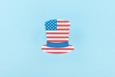 mavi arka plan üzerinde Amerikan bayrağından yapılmış kağıt kesim dekoratif şapka üst görünümü 