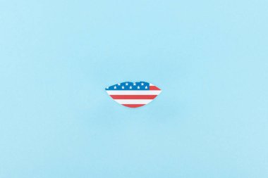 top view of paper cut decorative lips made of american flag on blue background  clipart