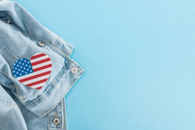 kopya alanı ile mavi arka plan üzerinde denim şık ceket üzerinde Amerikan bayrağı ndan yapılmış kağıt kesilmiş kalp üst görünümü