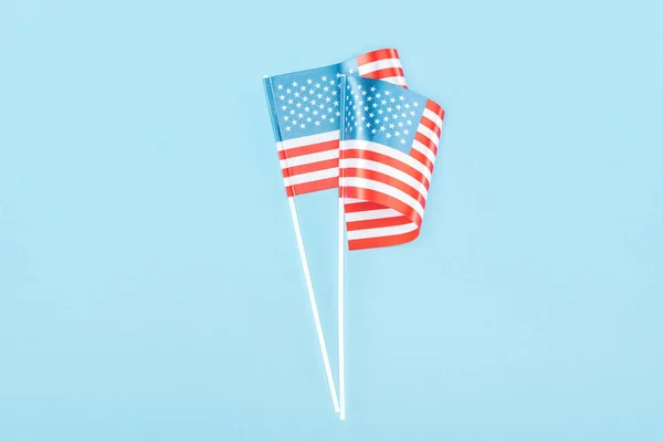Top Widok Dwóch Amerykańskich Flag Kije Niebieskim Tle — Zdjęcie stockowe
