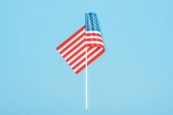 top view of decorative american flag on stick on blue background