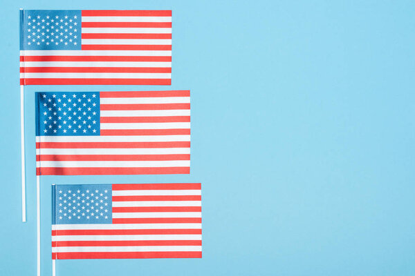 top view of usa flags on sticks on blue background