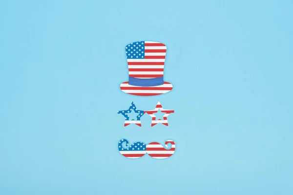 青い背景にアメリカの旗で作られた紙切りの口ひげ 帽子で平らに横たわっていた — ストック写真