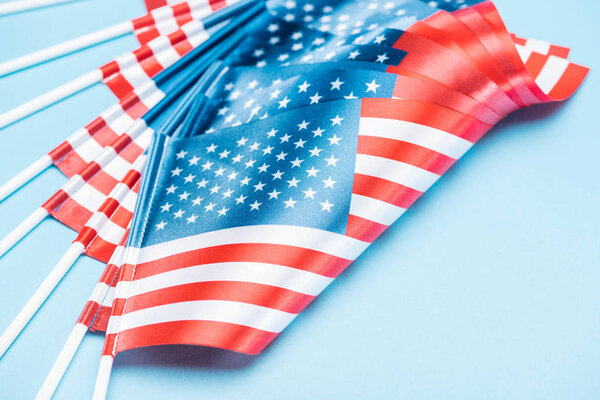 close up view of silk usa flags on sticks on blue background