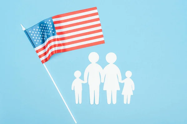 top view of paper cut family and american flag on blue background