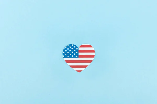 top view of paper cut decorative heart made of american flag on blue background 