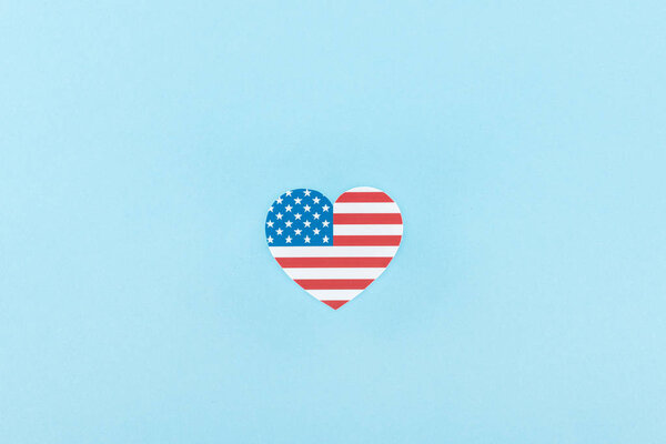 верхний вид бумаги вырезать декоративное сердце из американского флага на синем фоне
 