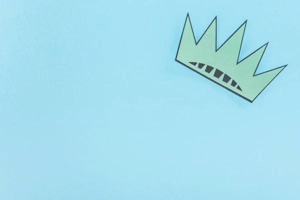 top view of paper cut crown on blue background with copy space, Independence Day concept