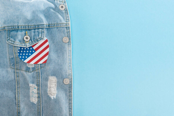 top view of paper cut heart made of american flag on denim jacket on blue background with copy space