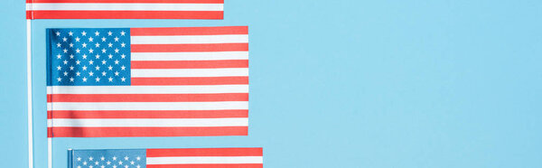 panoramic shot of national american flags on blue background