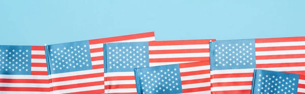 panoramic shot of national patriotic american flags on blue background