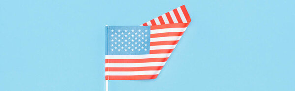 top view of american flag on stick on blue background, panoramic shot 