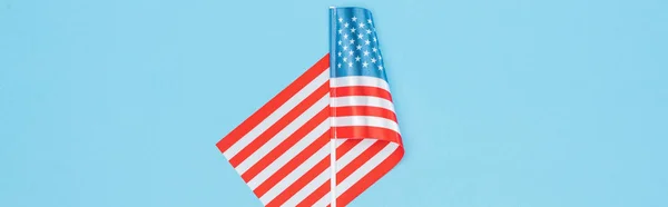 top view of national american flag on stick on blue background, panoramic shot 