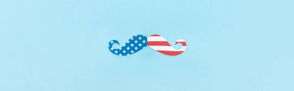 top view of mustache made of american flag on blue background, panoramic shot 