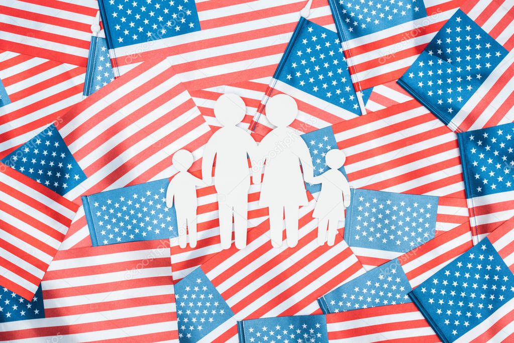 top view of white paper cut family on american flags background