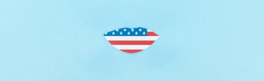 mavi arka plan üzerinde Amerikan bayrağından yapılmış kağıt kesilmiş dudaklar panoramik çekim 