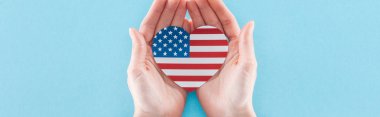 mavi arka plan üzerinde ulusal Amerikan bayrağı yapılmış kalp tutan kadın kısmi görünümü, panoramik çekim 