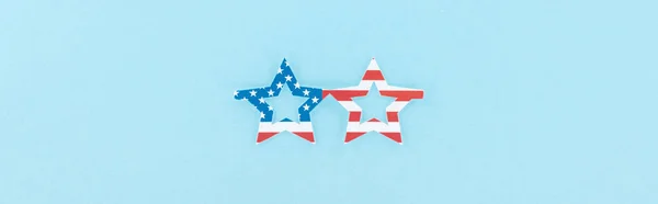 top view of paper cut decorative glasses made of american flag on blue background, panoramic shot 