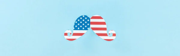 top view of paper cut decorative mustache made of american flag on blue background, panoramic shot 