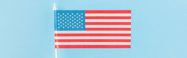 top view of decorative american flag on stick on blue background, panoramic shot