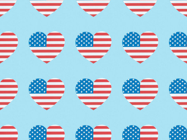 безseamless фон узор с вырезанными из бумаги сердечками из американских флагов на синем фоне
 