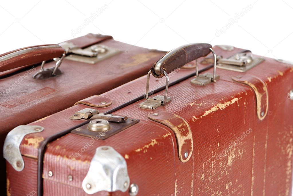 close up view of two vintage brown leather suitcases isolated on white